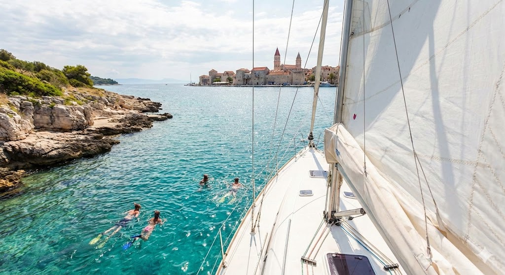 People wimming alongside a moored yacht